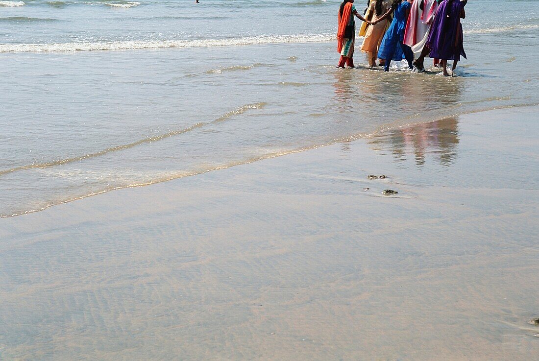 Fünf Frauen in bunten Saris am Strand, Goa