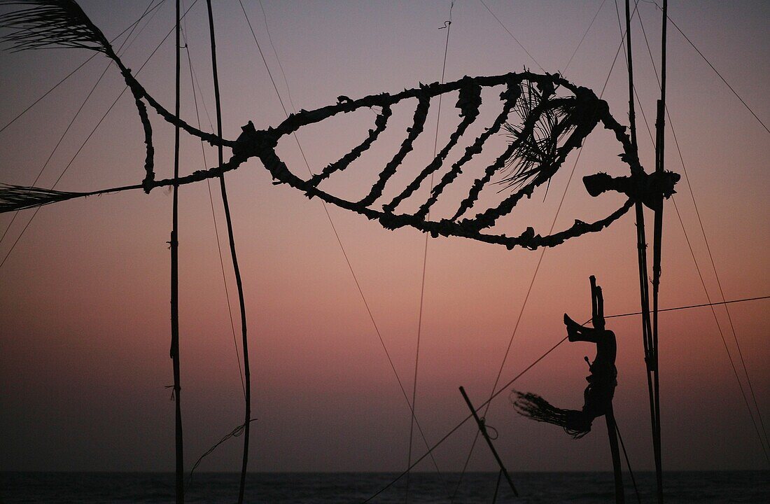 Silhouetten der Person, die Akrobatik auf dem Strand bei Sonnenuntergang