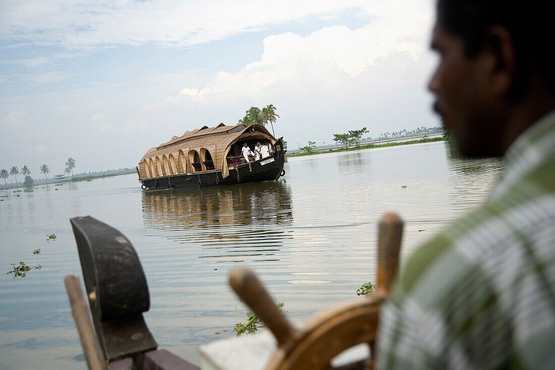 Man At Steering Wheel Of House Boat