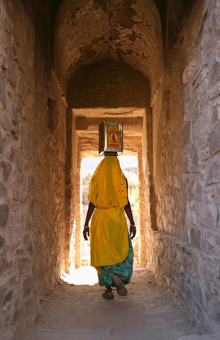 Woman With Box On Her Head Walking Through Alleyway