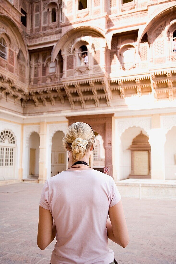 Blonde Touristin betrachtet ein Gebäude im Fort Mehrangarh