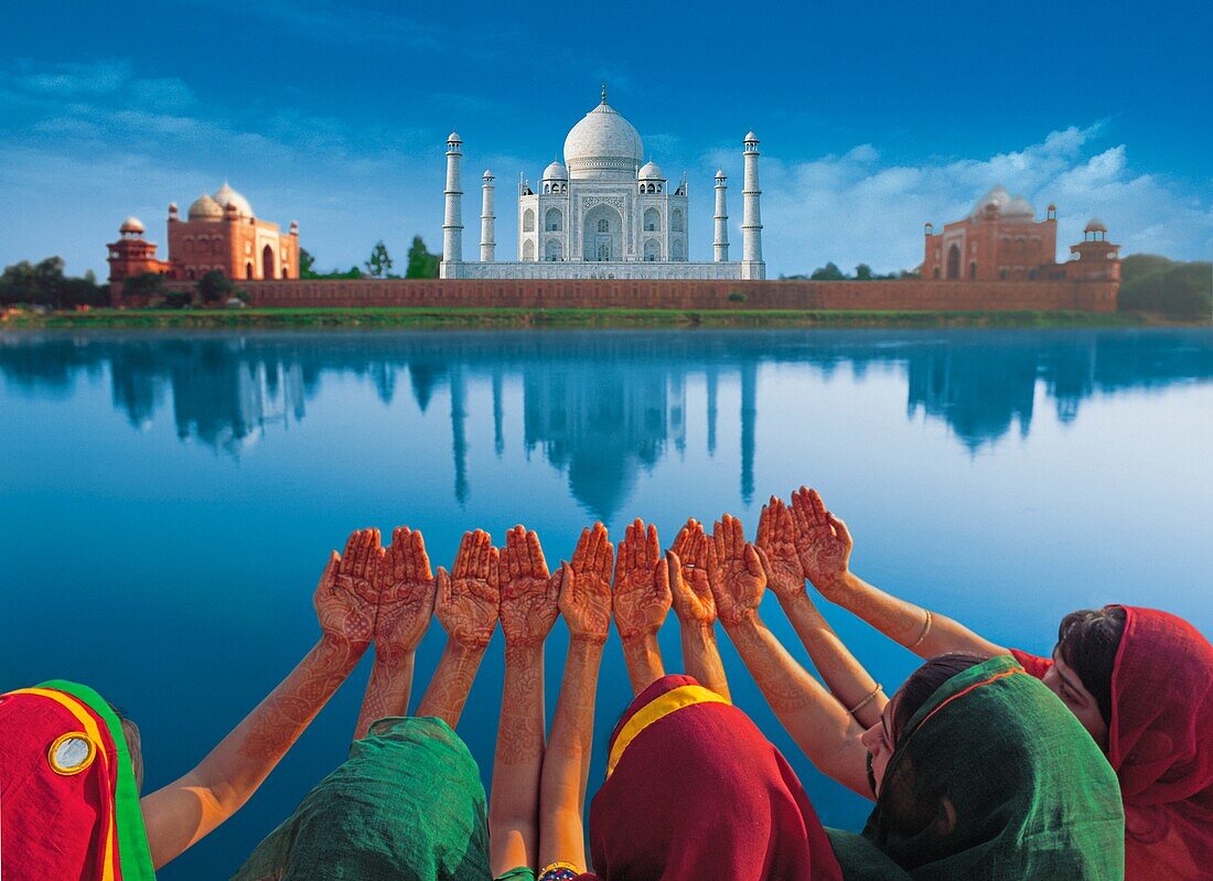 Women In Saris Holding Their Hands Up In Front Of The Taj Mahal