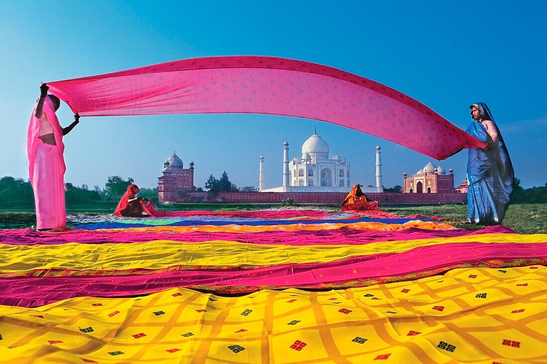 Frauen in Saris mit dem Taj Mahal im Hintergrund