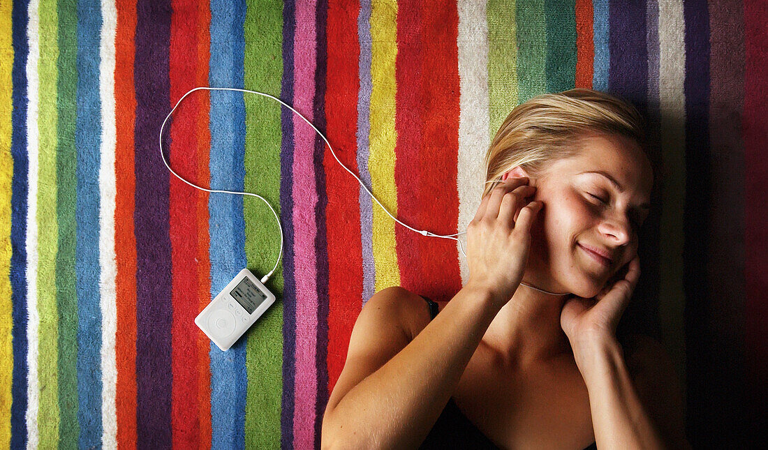 Woman Listening To An Ipod On A Colorful Rug