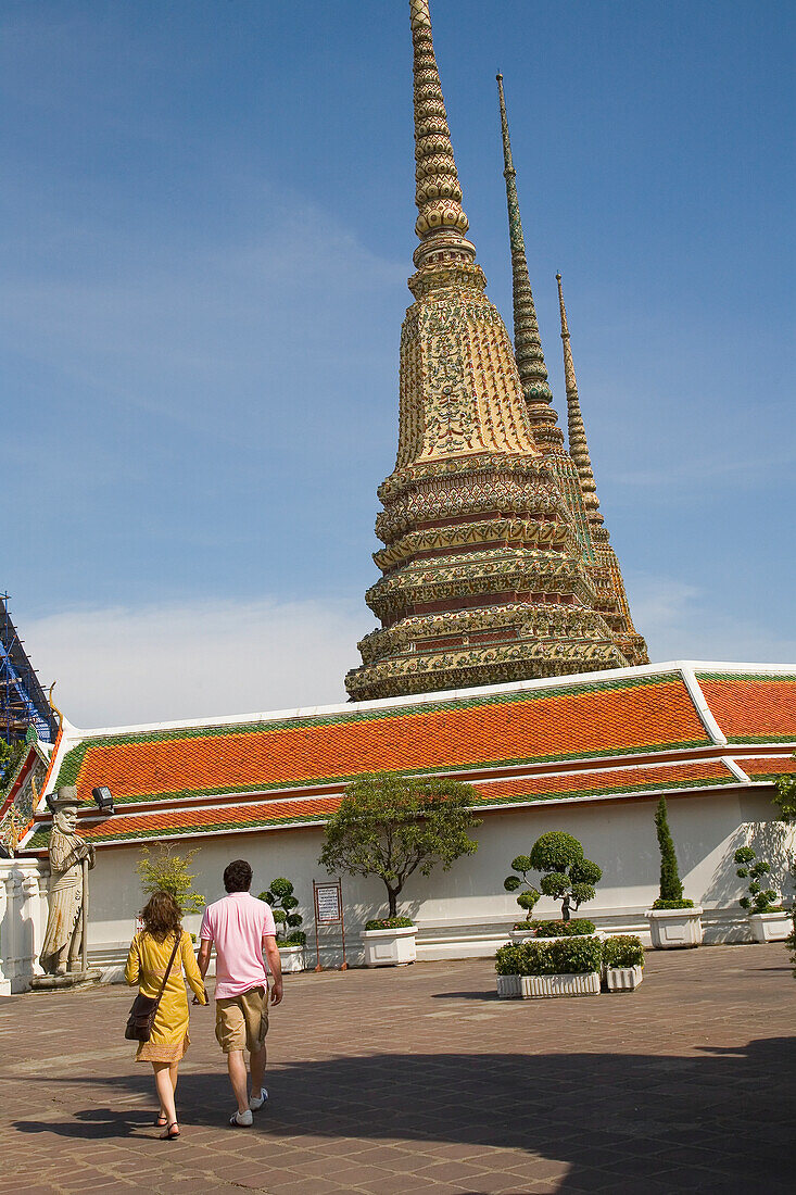 Pärchen im Wat Pho mit westlichen Hof-Chedis im Hintergrund