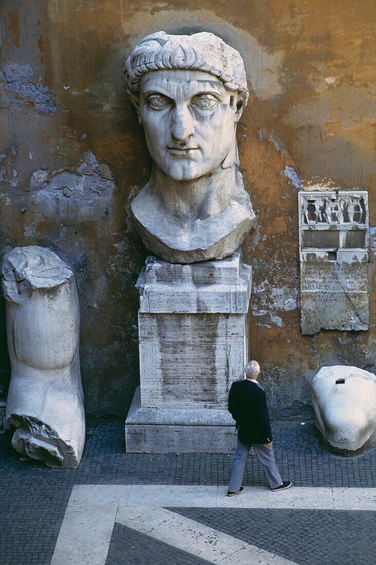 Mann geht an Statuen im Innenhof des Palazzo Dei Conservatori vorbei