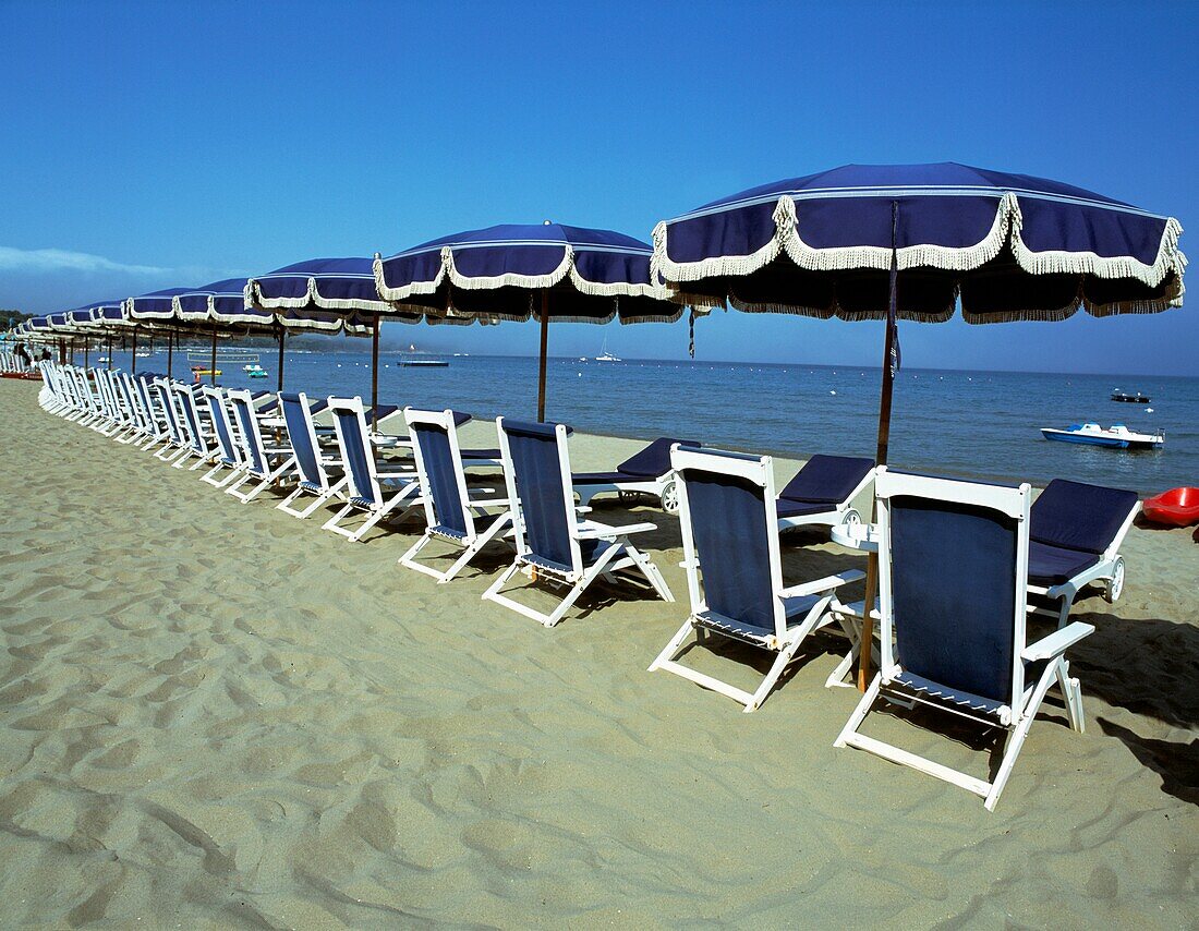 Leere Liegestühle und Sonnenschirme am Strand