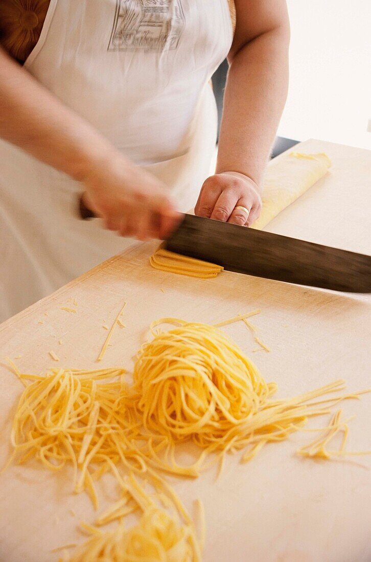 Cook Making Tagliatelli Pasta By Cutting Rolled-Up Sheet Of Pasta, La Vecchia Scuola