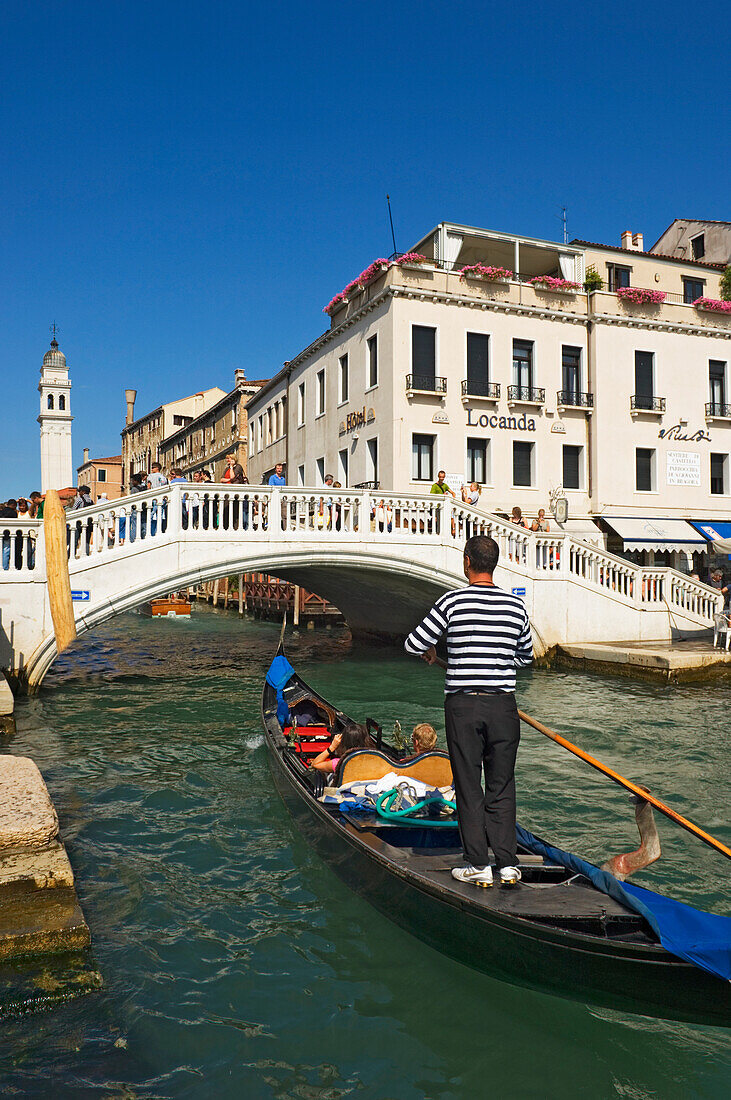 Gondolier On Gondola In Canal In Venice.