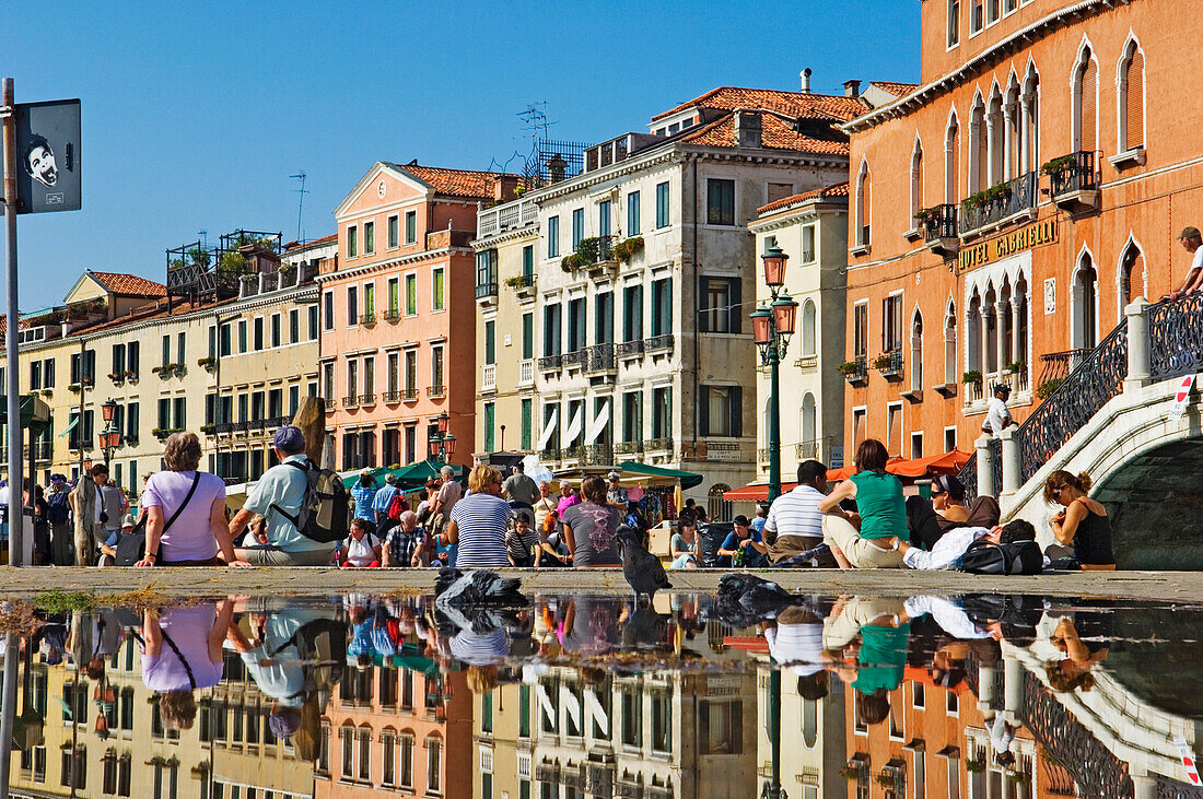 Tourist, der sich am Brunnen in Venedig ausruht.