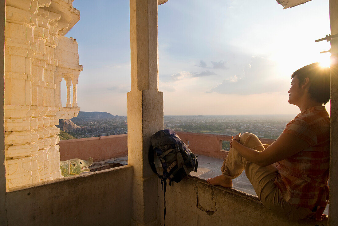 Woman Sitting In Small Temple At Dusk