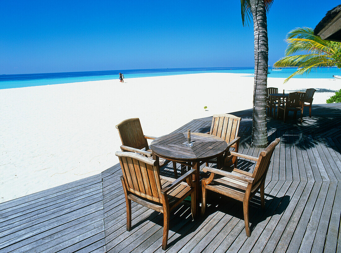 Stühle und Tisch auf dem Deck am Strand