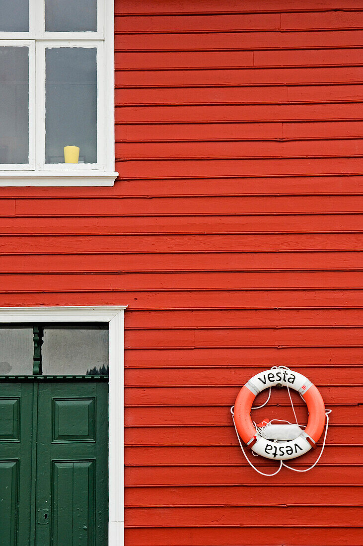 Life Ring Hanging On Red Clapboard House