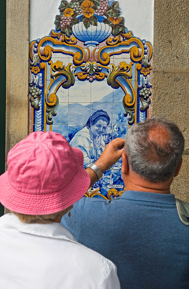 Paar beim Fotografieren einer Quinta-Tafel am Bahnhof von Pinhao