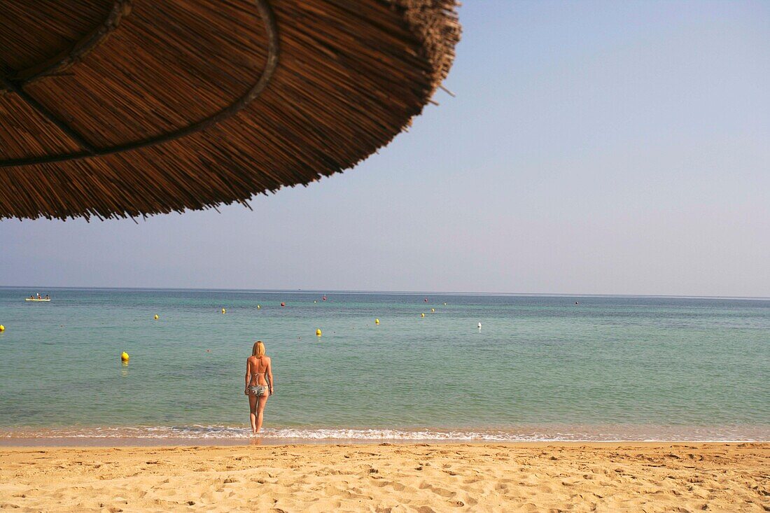 Woman Standing In Water On Beach