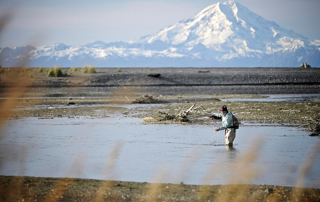 Frau beim Fliegenfischen auf Steelhead am Deep Creek mit Mt. Redoubt im Hintergrund, Kenai Halbinsel, Süd-Zentral-Alaska, Herbst