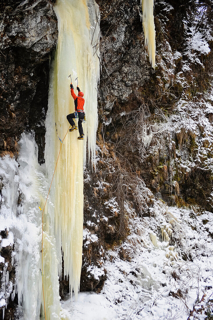 Eiskletterin erklimmt einen großen Eisfall in Süd-Zentral-Alaska