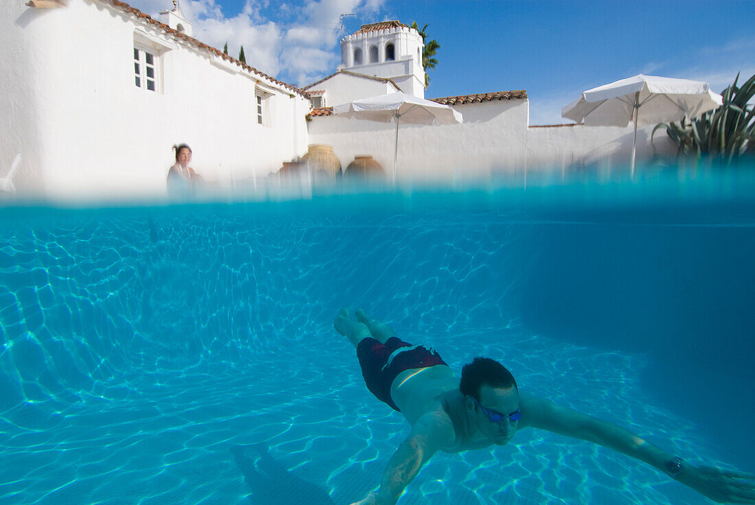 Mann schwimmt unter Wasser im Schwimmbad