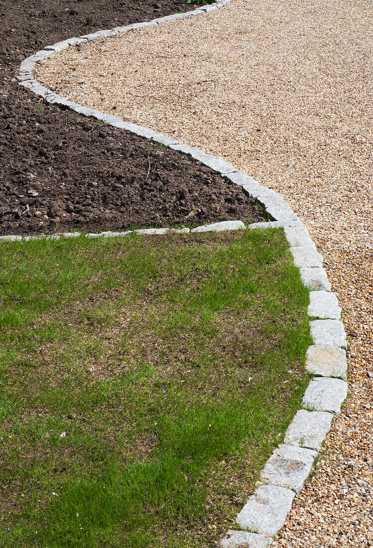 Garden floor divided with three different elements, grass, soil and pebbles; Coulsdon south, surrey, england