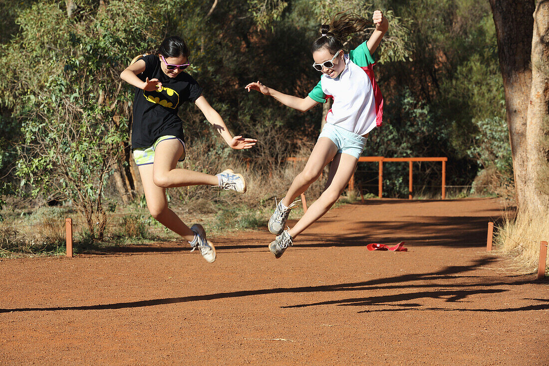 Two Girls Leaping In The Air Together; Australia