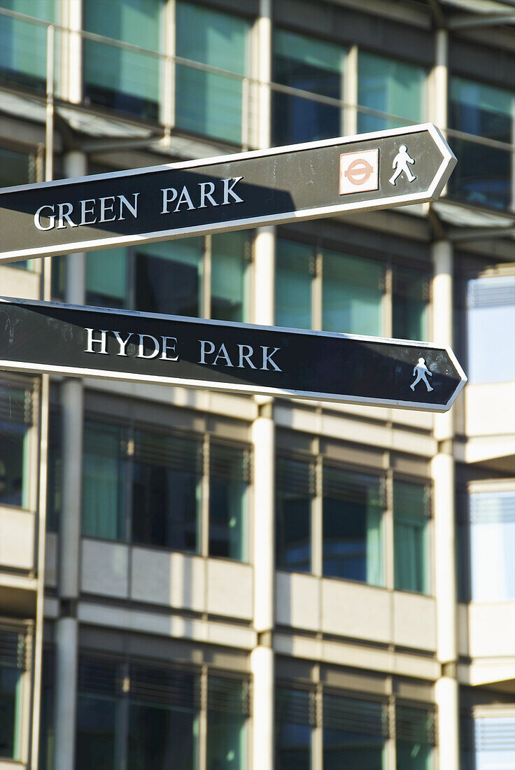 Hinweisschilder für Green Park und Hyde Park mit einem Gebäude im Hintergrund; London, England