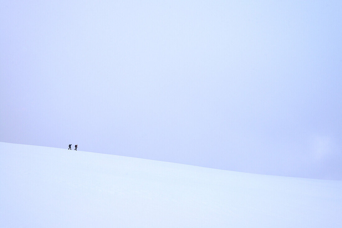 Zwei Personen wandern bei schneebedeckten, winterlichen Bedingungen am Beinn An Dothaidh in der Nähe von Bridge Of Orchy entlang; Argyll und Bute, Schottland