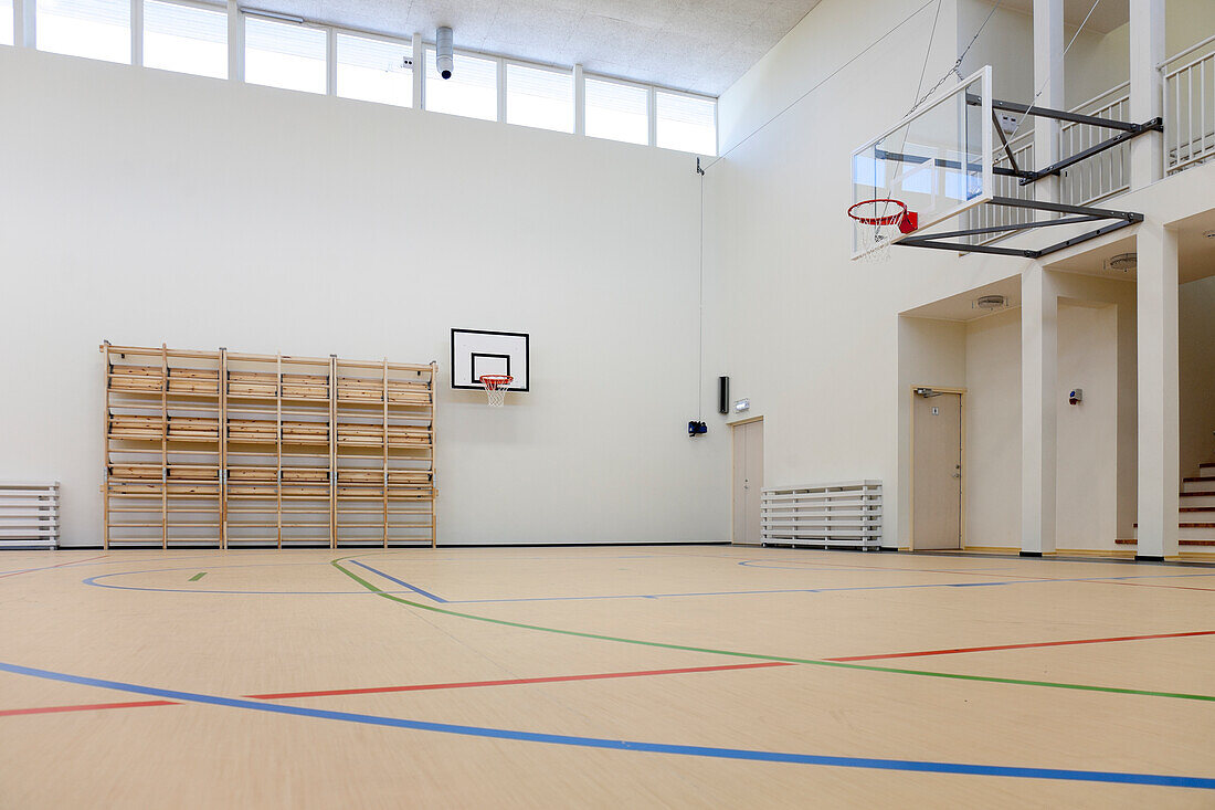 Indoor-Basketballplatz in einer Schule. Holzfußboden und markiertes Spielfeld, ein Korb und ein Brett.