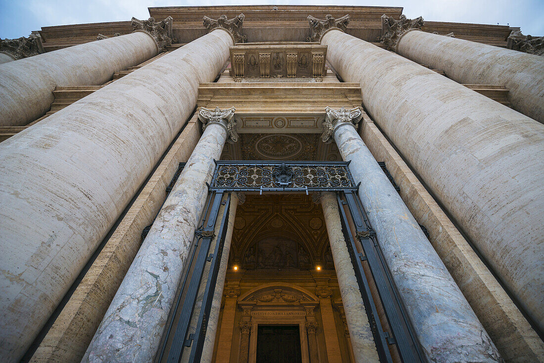 Niedriger Blickwinkel auf den Petersdom mit großen Säulen um ein Portal; Rom, Latium, Italien