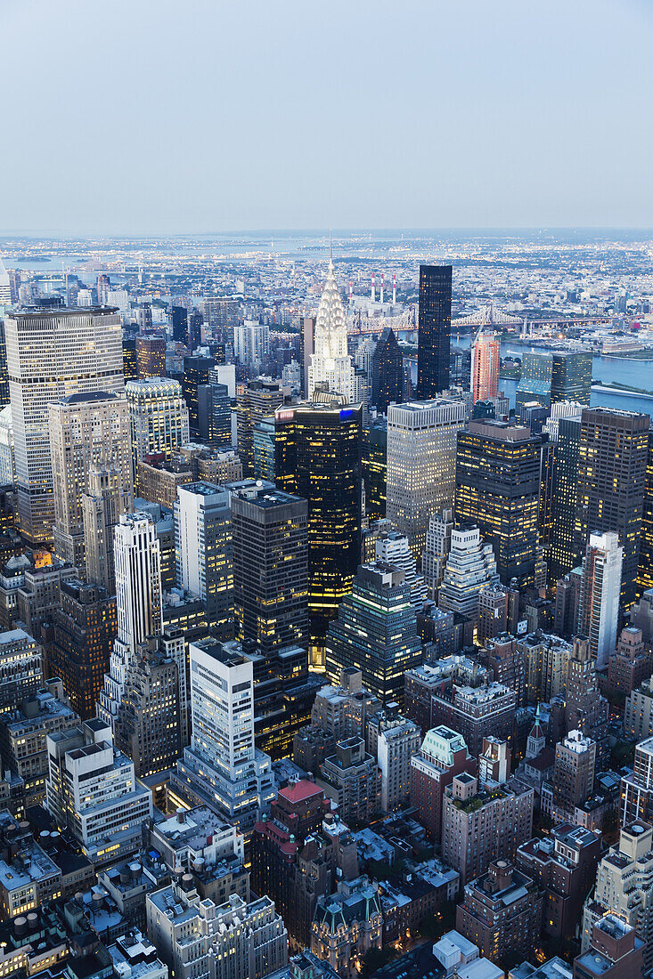 Panoramablick auf die Wolkenkratzer und den East River in der Abenddämmerung, vom Empire State Building aus gesehen, New York City, New York, Vereinigte Staaten