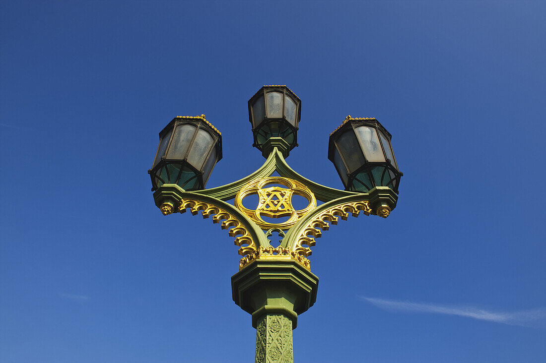 Low Angle View Of An Ornate Lamp Post Against A Blue Sky; London, England