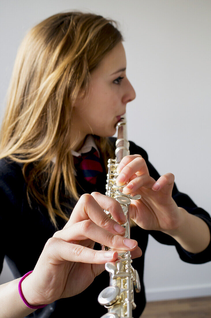 Flöte spielendes Mädchen in Schuluniform; England