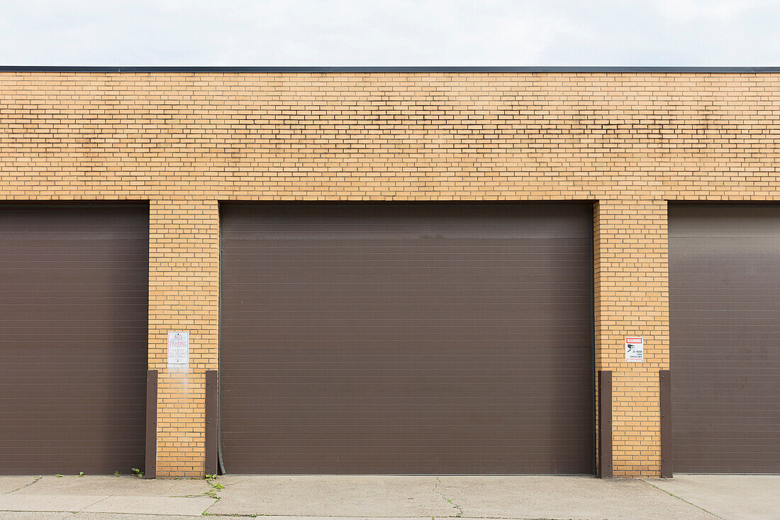Exterior of industrial warehouse roll down doors and doorway pillars. 