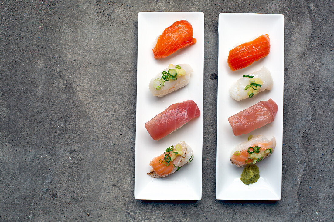 Eine Sushi-Platte mit frischem Fisch und Reis, sorgfältig auf dem Teller angerichtet und garniert. 