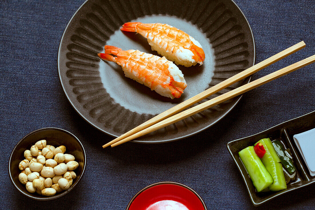 Garnelen und Reis auf einem blauen Teller mit Essstäbchen. 
