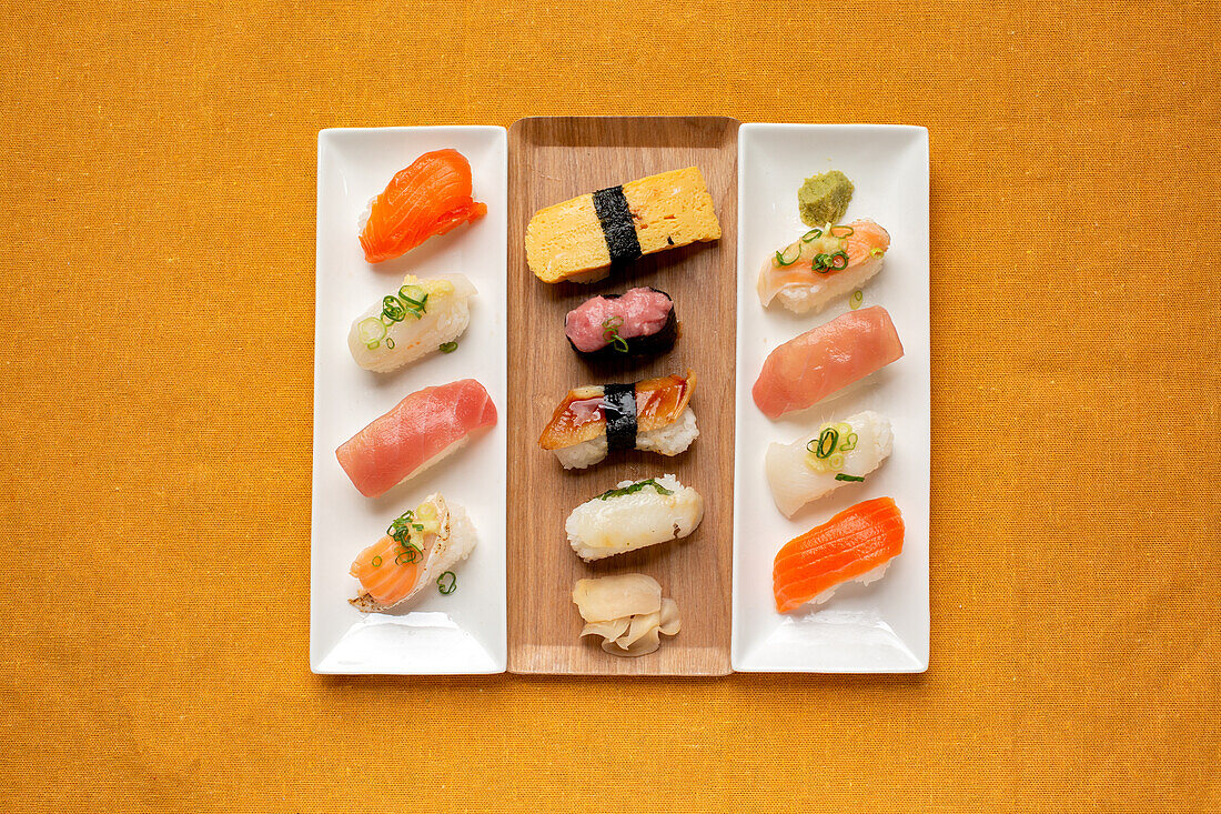 Sushi-Platte, eine Auswahl an rohem Fisch und Reissnacks mit Essstäbchen. 