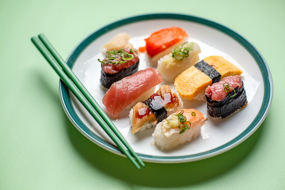 Sushi platter, a selection of raw fish and rice snacks with chopsticks. 