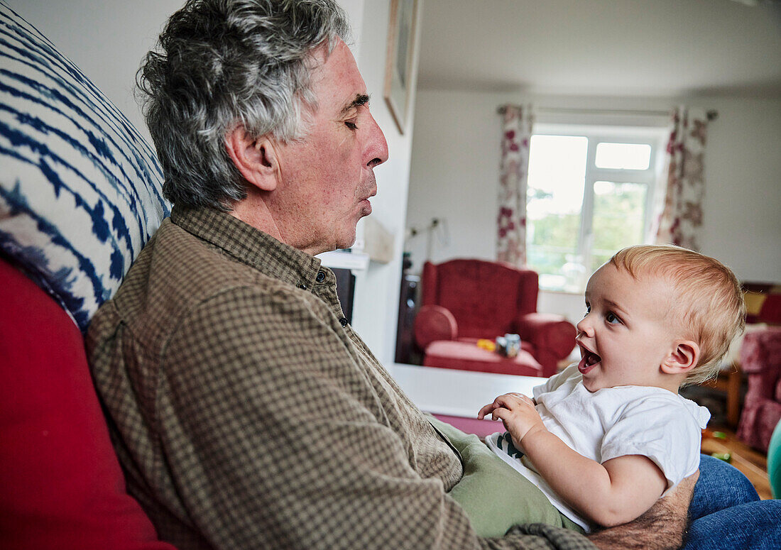 Close up of smiling toddler in arms of grandfather