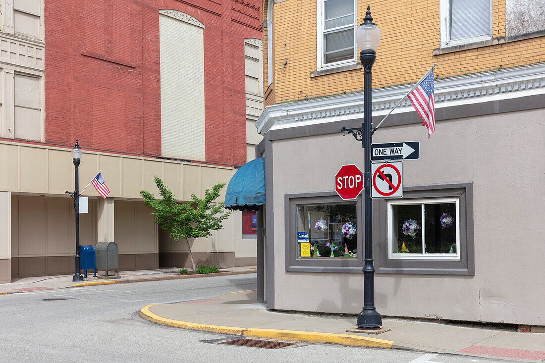 Intersection of roads in a small town with American flags, flying on Memorial Day.