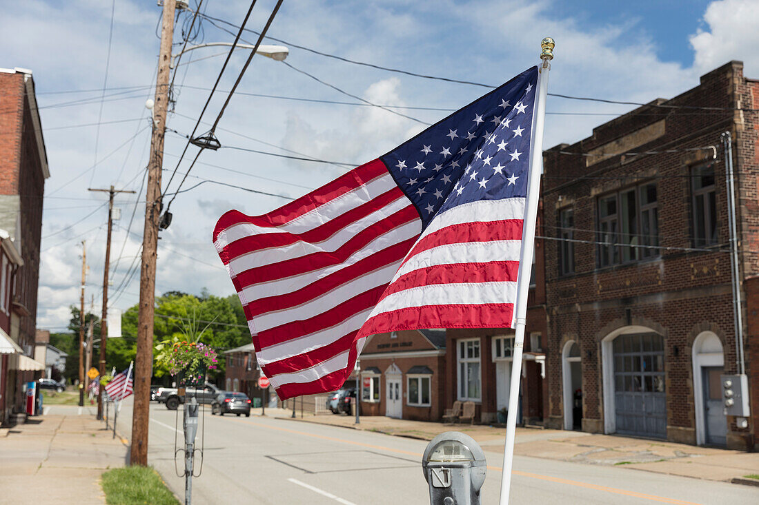 Amerikanische Flagge flattert in der Brise auf einer verlassenen Hauptstraße.