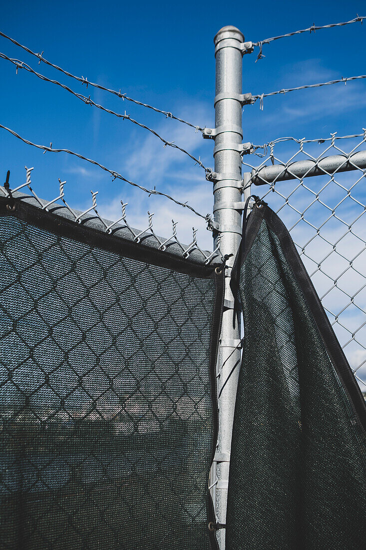 A barbed wire fence and draped fabric