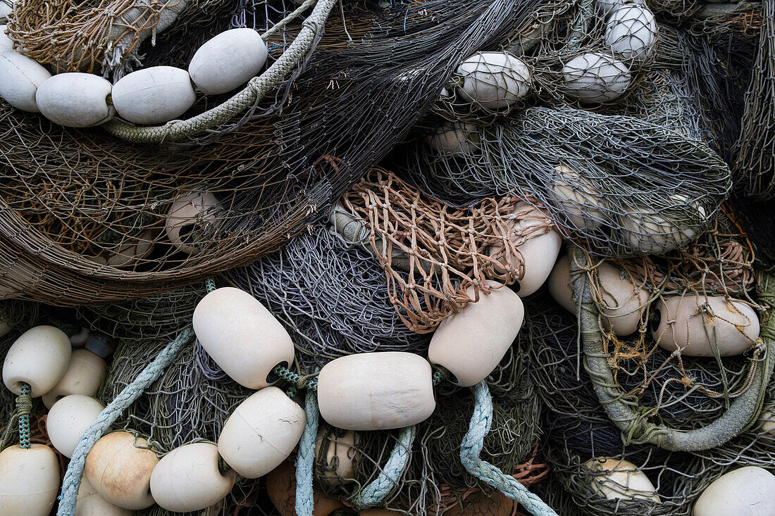 A pile of commercial fishing nets with ropes and floats. 