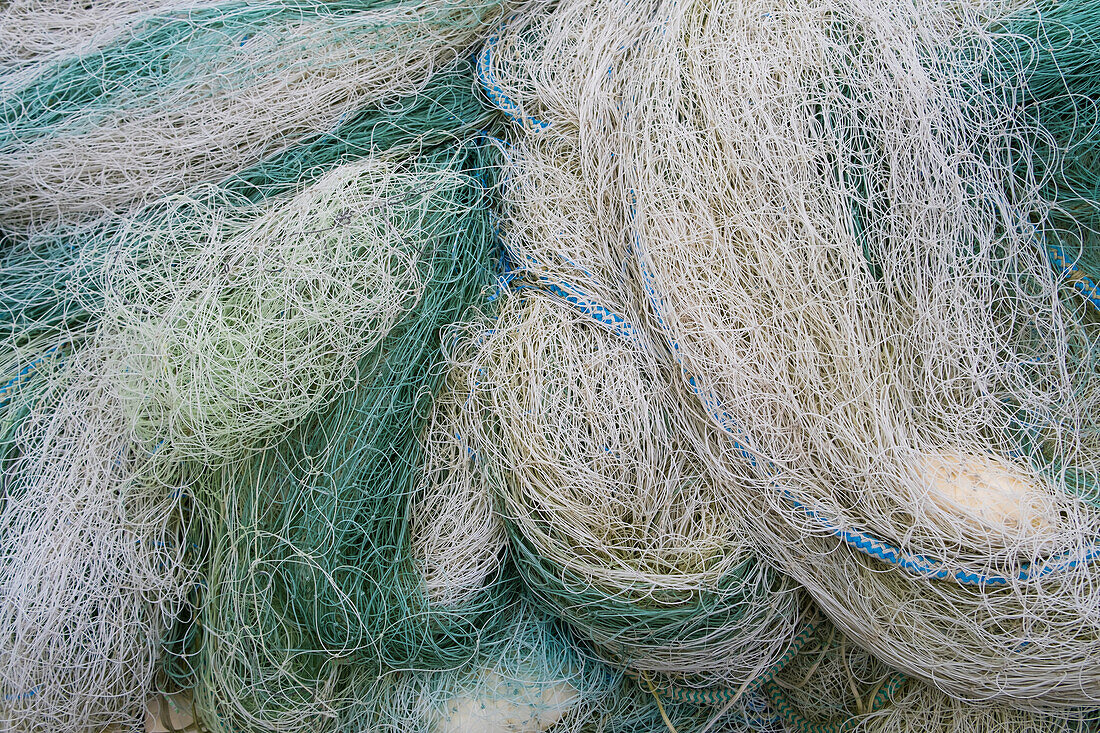 A pile of commercial fishing nets, blue green and white. 