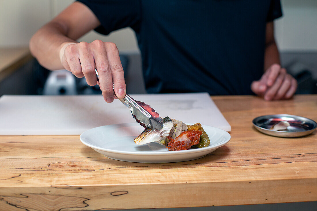 A chef preparing plates of tapas food in a restaurant.