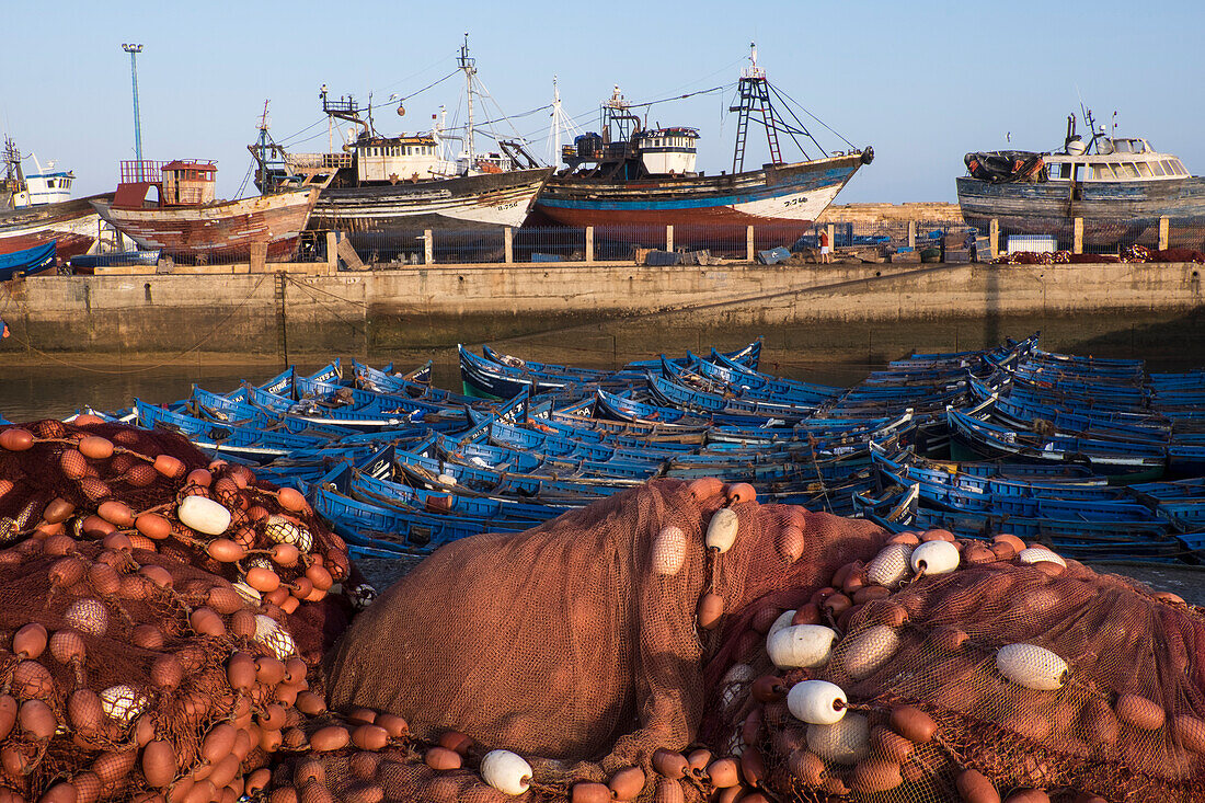 Marokko. Fischernetze, Schwimmer, Boote und kommerzielle Fischereifahrzeuge des Hafens in Essaouira.