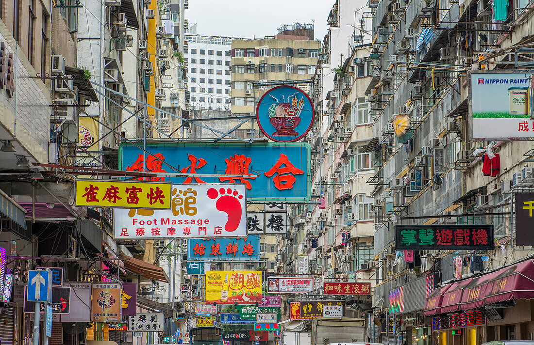 Hong Kong, China. Traffic Kowloon Woosung Street with signs overhanging street