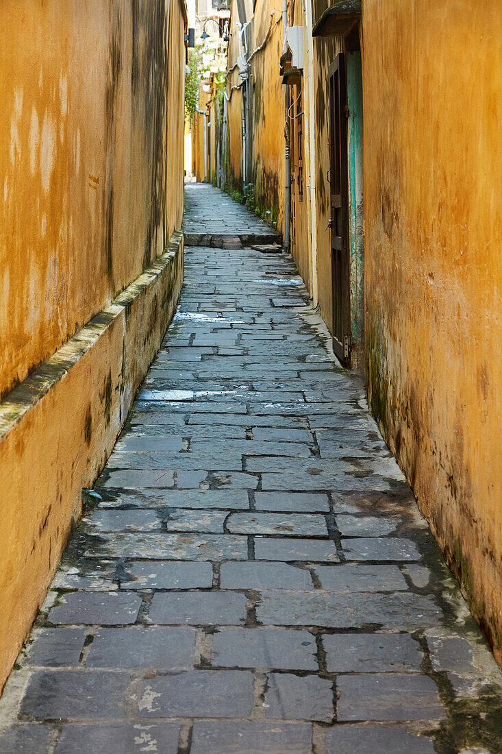 Cobblestones and yellow walls in alleyway, Hoi An (UNESCO World Heritage Site), Vietnam