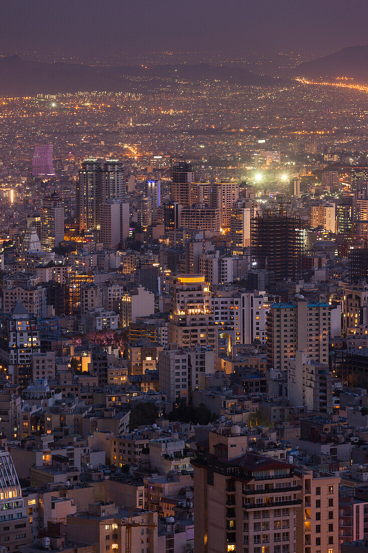 Iran, Teheran, Erhöhte Stadtsilhouette mit Blick vom Dach des Iran-Parks auf den Milad-Turm, Abenddämmerung