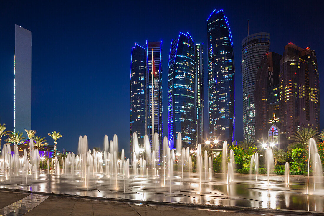 UAE, Abu Dhabi. Emirates Palace Hotel fountains and Etihad Towers