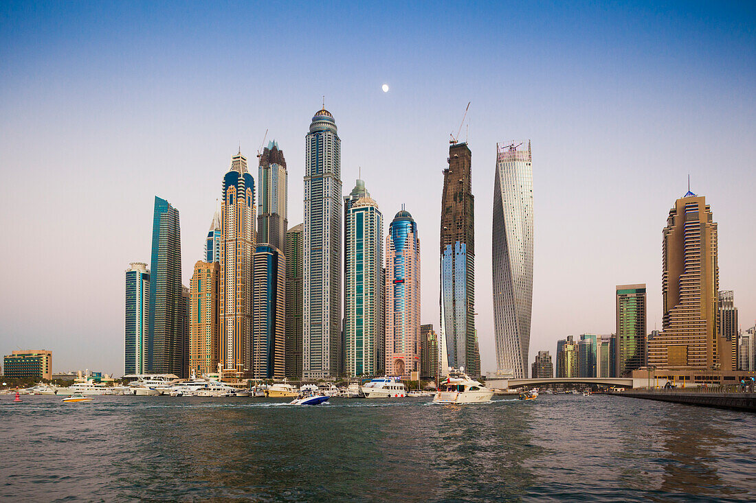 UAE, Dubai Marina high-rise buildings including the twisted Cayan Tower, with moonrise
