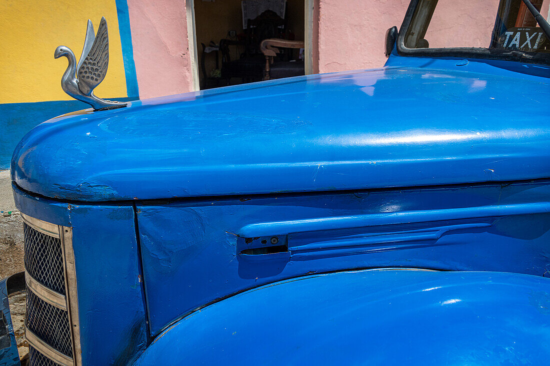 Detail eines klassischen blauen amerikanischen Autos mit verchromter Schwanenhaube in Trinidad, Kuba.